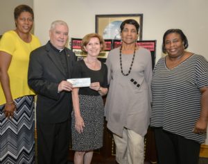 Eileen Larum, Board Member of the Chi-Town Jazz Festival presents a check to Catholic Charities, received by Msgr. Boland and Father Wayne at St. Vincent Center in Chicago.